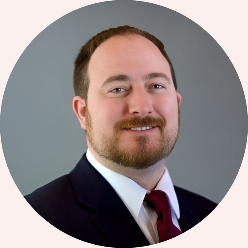 Professional headshot of Dr. Mark Evers, team member at Concurrent Wealth Management, wearing a dark suit and red tie.