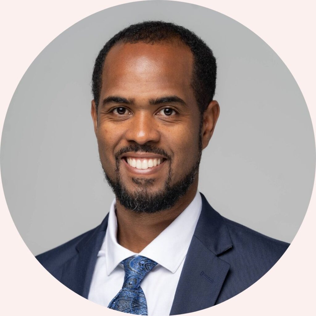 Professional headshot of Dr. Philip Gibson, team member at Concurrent Wealth Management, wearing a navy suit and patterned tie.