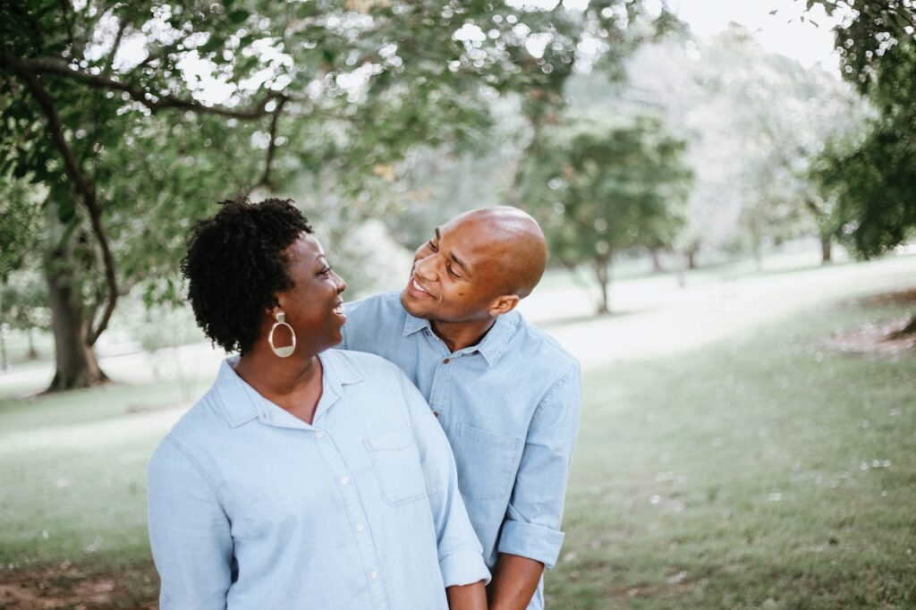 Happy couple smiling and walking together in a park, symbolizing love, connection, and quality of life.
